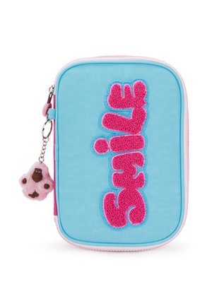 Pochette bleue avec une fermeture éclair, ornée d'un patch rose avec le texte « Smile » et un porte-clés en peluche de singe rose attaché à la tirette.