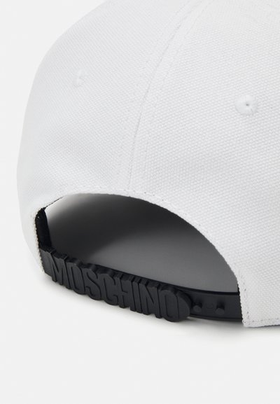 Căciulă de baseball albă, cu un material texturat, curea din cauciuc negru cu marcajul "MOSCHINO" la spate și orificii de ventilație pe coroana căciulii.
