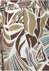 Patterned fabric featuring abstract, leaf-like designs in brown, green, blue, and beige tones with a textured, woven appearance.
