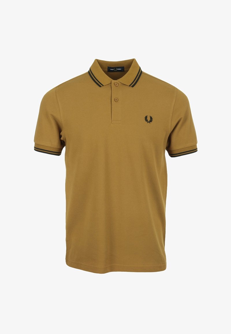 Polo shirt jaune moutarde en coton avec un col classique, patte de boutonnage à trois boutons et bord noir rayé sur les manches. Présente le logo sur la poitrine.