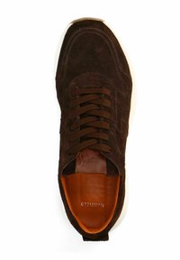 Bruine suède sneakers met ronde neus, donkerbruine veters en een contrasterende witte rubberen zool. Het interieur heeft een oranje inlegzool met merknaam.