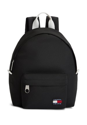 Sac à dos noir Tommy Jeans avec poche zippée frontale et détail de poignée blanche sur fond blanc uni.