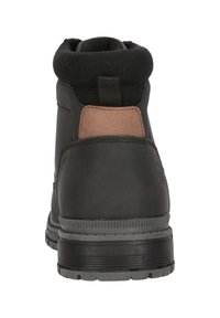 Svart läderstövel med vadderad krage, brunt accent vid hälen och texturerad gummisula. Har en dragflik för enkel påtagning.