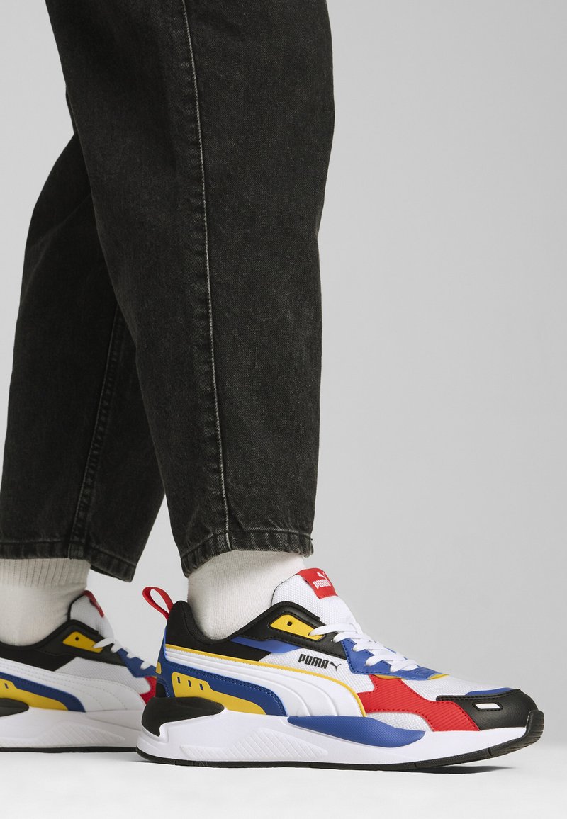 Puma sneakers med en färgkombination av svart, vitt, rött, blått och gult; mesh- och syntetmaterial; texturerad sula; vadderad krage.