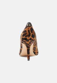 Scarpa con tacco alto in stampa leopardata, caratterizzata da una punta affusolata, tessuto morbido, tacco nero e un accento dorato con logo sul retro.