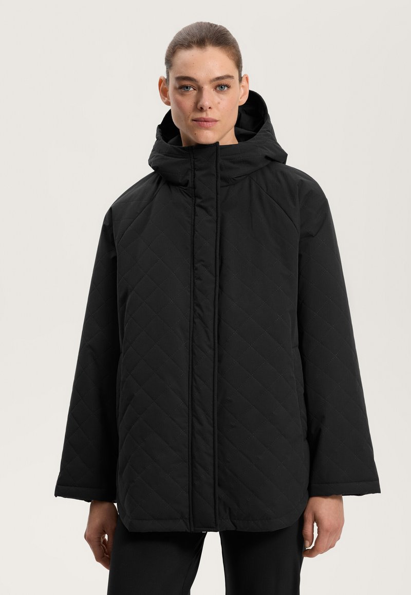 Črna, quiltana puffer jakna s kapuco. Ima ravno krojenje, dolge rokave in sprednji zadrgo. Mat tekstura, minimalističen oblikovanje.