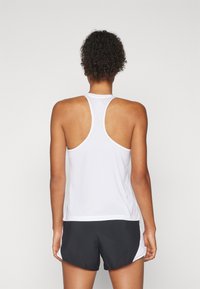 White sleeveless athletic tank top with a racerback design, paired with black shorts featuring white side accents. Smooth, lightweight fabric.