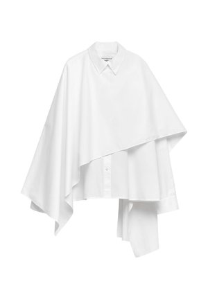 Asymmetrisk vit skjorta med knappar, bred krage och ett draperat överlägg som sträcker sig ojämnt på ena sidan.