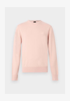 Pull rose clair à manches longues avec col rond, poignets et ourlet côtelés, avec un petit patch logo discret sur la poitrine gauche.