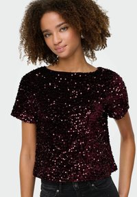 Burgundijas krāsas spīguļošs tops ar apaļu kakla izgriezumu un īsām piedurknēm, ar teksturētām mirdzošām rotājumiem un pielāgotu siluetu.