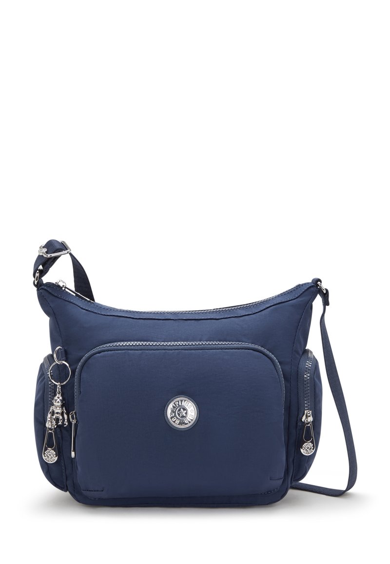 Marineblå crossbodytaske lavet af blødt stof, med sølvfarvede lynlåse, forlommer og en dekorativ charme med et cirkulært logo.