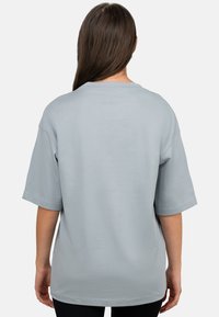 T-shirt bleu clair à manches courtes en coton doux, avec une coupe décontractée et un design simple. Aucun motif ou accent visible.