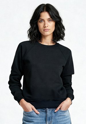 Felpa nera girocollo con maniche raglan, realizzata in materiale morbido. Presenta polsini e orlo a coste, abbinata a jeans blu chiaro.