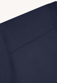 Camiseta azul marino con una textura suave, que presenta un escote redondo y un detalle sutil en la costura del hombro.