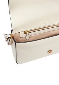 Witte leren tas met een ritsvak, gouden hardware en een beige voering. Heeft een drukknoopsluiting en zwarte afwerking.