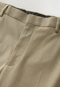 Beige gestreifte Hose mit flachem Frontschnitt und Seitentaschen. Der Stoff hat eine subtile Textur, und der Bund ist mit einer glatten Naht verarbeitet.