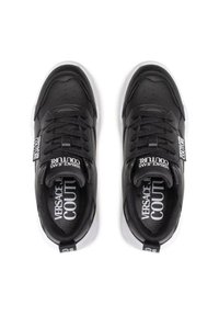 Sneaker in pelle nera con suole in gomma bianca. Le caratteristiche includono lacci, parte superiore perforata e logo sulla linguetta e sul lato.