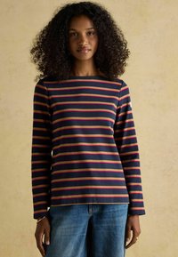 Tumedast sinine triibuline pikkade varrukatega topp, millel on horisontaalsed roosa ja oliiviroheline triibud, ümar kaelus ja mugav lõige. Puuvillase segu materjal.