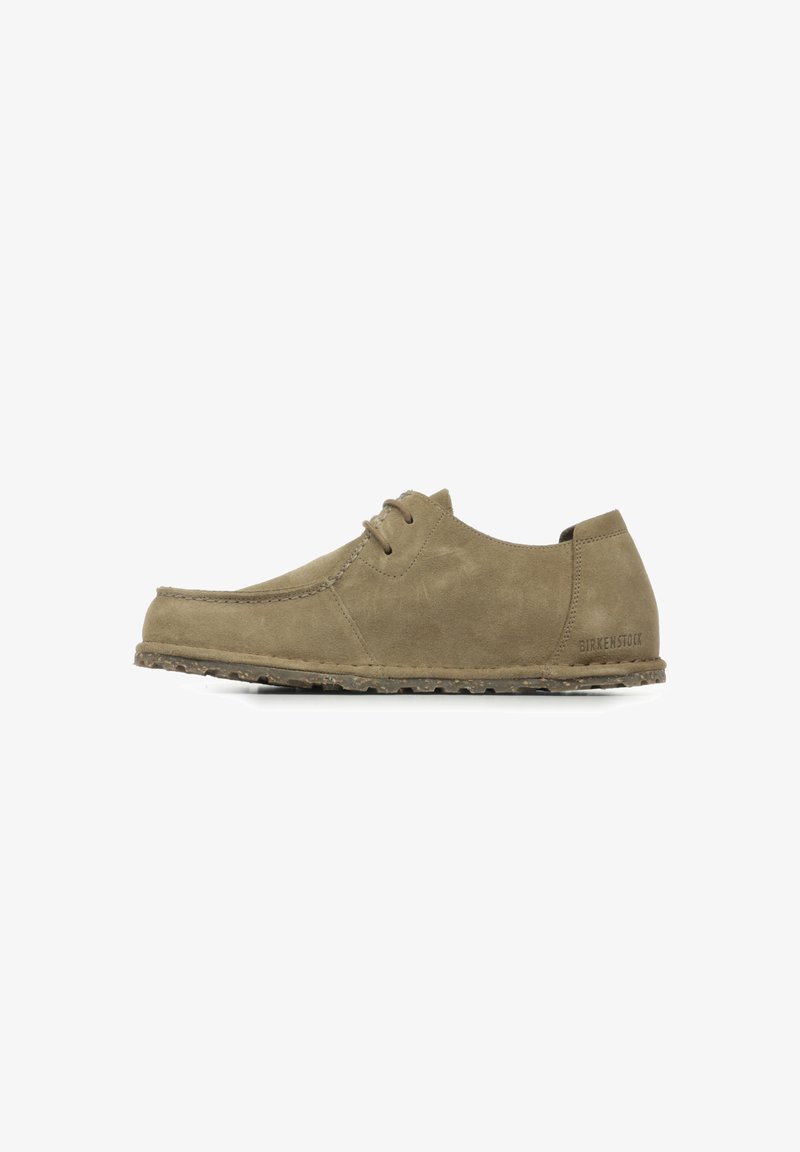 Light brown suede shoe with a rounded toe, lace-up design, and textured sole. Features subtle branding on the heel.