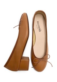 Ballerine in pelle marrone con punta rotonda, tacco basso e un fiocco decorativo sul davanti con un bordo texturizzato.