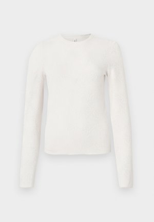 Hvid langærmet top med et præget blomsterrelief, rund halsudskæring og en tætsiddende silhuet. Glat tekstur uden synligt hardware.