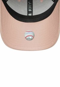Gorra de béisbol con una tela rosa suave, un visor negro y un logo circular que se asemeja a una pelota de béisbol en la parte frontal. Diseño elegante y forma estructurada.