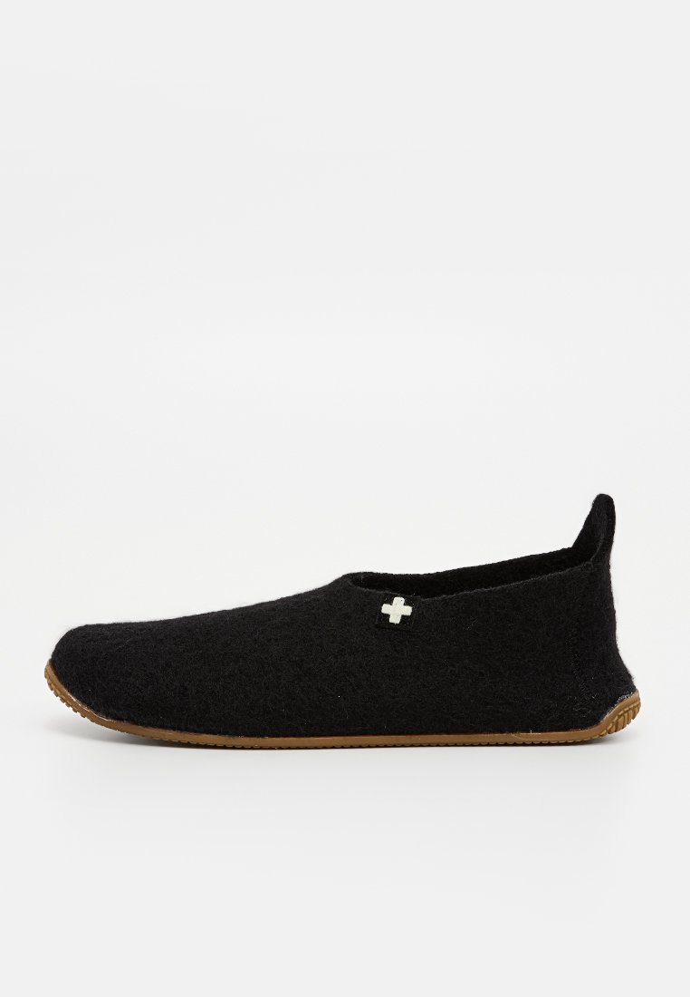 Schwarze Filzhausschuhe mit niedrigem Profil, Gummisohle und einem kleinen weißen Kreuzakzent an der oberen Seite. Weiche Textur und minimalistisches Design.