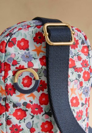 Blumenbeutel mit hellblauem Grund, verziert mit roten und lila Blumen sowie orangen Sternen. Goldene Hardware mit einem navyfarbenen Tragegurt sorgt für einen Kontrast.