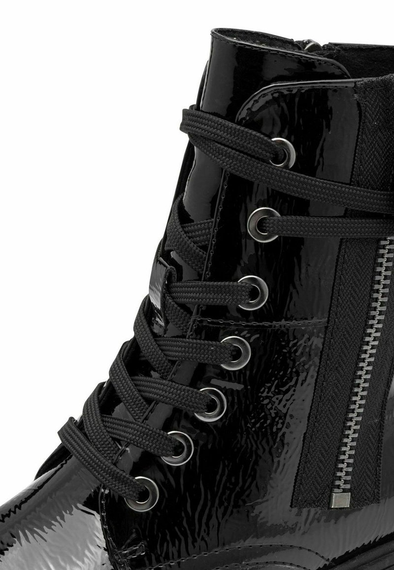 Schwarze Lackleder-Stiefelette mit strukturiertem Obermaterial, schwarzen Schnürsenkeln, Metallösen und einem seitlichen Reißverschlussdetail mit Stoffakzent.