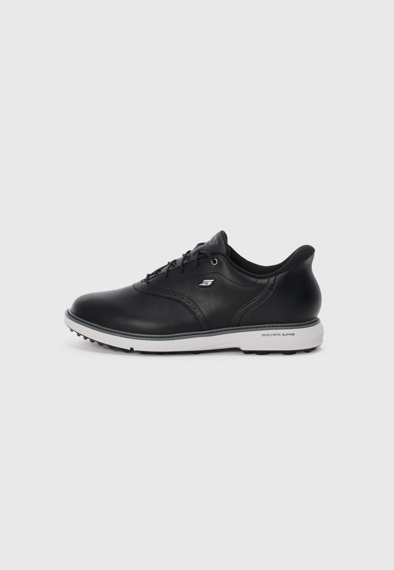 Baskets Skechers noires en cuir avec lacets et semelle blanche, logo sur le côté et texture de grip sur la semelle, sur fond clair uni.