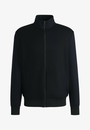 Musta vetoketjullinen takki korkealla kauluksella, jossa on kiinteää kangasta, ribattu hihansuut ja helma sekä sivutaskut. Sileä pinta, moderni muotoilu.