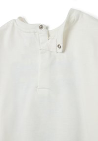 Camisa de algodón blanca con cuello redondo y cierre de botón a presión, textura suave y diseño minimalista, que enfatiza la simplicidad y la practicidad.