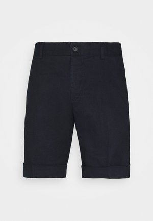 Pantaloncini neri su misura fino al ginocchio con orli risvoltati, passanti per cintura e chiusura con bottone in vita su sfondo bianco.