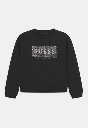 Czarna bluza z długim rękawem i okrągłym dekoltem z białym, pikselowym logo "GUESS" oraz napisem "LOS ANGELES" poniżej na przodzie.