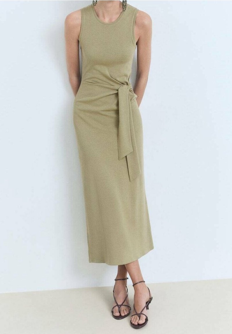 Vihreä oliivinvärinen hihaton mekko pehmeästä kankaasta, jossa on kierrerintakuvio ja sidottu yksityiskohta. Polvenmittainen ja rento istuvuus.
