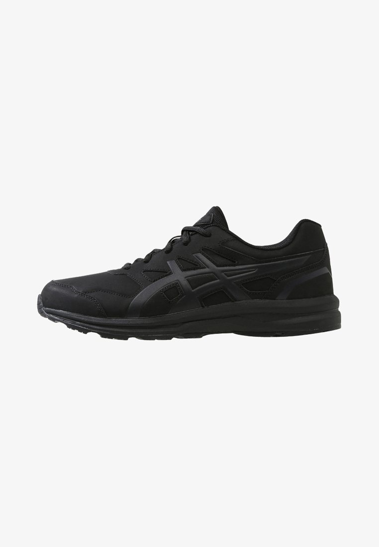 Baskets de sport noires basses avec fermeture à lacets et semelle texturée, avec un motif de logo subtil sur le côté.