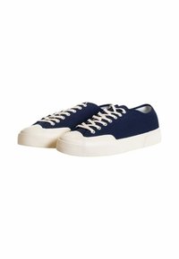 Sneaker in tela blu con lacci bianchi, punta in gomma e suola texturizzata. Presenta un design a bassa altezza e una forma arrotondata.