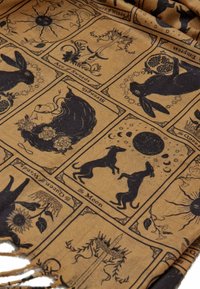 Tarot tematika skara tan spalvos su juodais gyvūnų ir simbolių piešiniais, turinti sudėtingus dizainus ir puošnius kraštus.