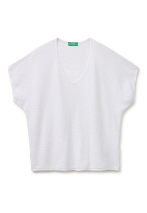 Camiseta de punto blanca de manga corta con cuello en V y ajuste suelto, con una etiqueta verde de United Colors of Benetton en el cuello.