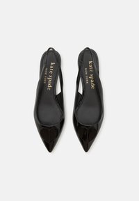Melna lakota āda slingback papēžu kurpes ar smailu purngalu un sirds formas akcentu. Iekšpusē apaviem ir zelta teksta zīmols.