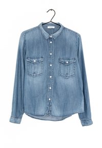 Camicia in denim con maniche lunghe, colore azzurro chiaro, chiusura frontale con bottoni, due tasche sul petto e colletto classico. Tessuto morbido con dettagli cuciti.