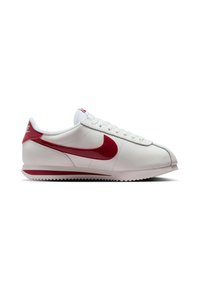 White low-top Nike sneaker with red swoosh logo, red heel tab, and white sole with red stripe, shown from the outer side.