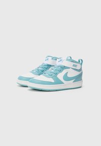 Baskets montantes Nike en bleu clair et blanc, avec un dessus texturé, une boîte à orteils renforcée et une sangle en Velcro pour un ajustement sécurisé.