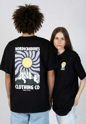 Musta t-paita, jossa on "NORDICBUDDIES" -logo. Takana on design, jossa on aurinko ja sarjakuvahahmot. Pyöreä kaula-aukko, lyhyt hiha, rento istuvuus.