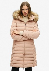 Giacca imbottita di colore rosa chiaro con cuciture orizzontali, cappuccio con bordo in pelliccia, zip completa e polsini a coste. Progettata per calore e comfort.