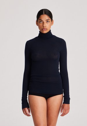 Maglia a maniche lunghe con collo alto in un blu scuro, realizzata in un tessuto morbido e leggero. Caratterizzata da un design aderente e aperture per il pollice nelle maniche.