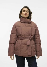 Puffy, mauve jakke med høy krage og belte i midjen. Har kvadratiske quiltede seksjoner og sidelommer. Myk, glatt tekstur.