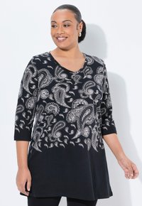 Schwarze Tunika mit silbernem Paisleymuster, V-Ausschnitt und Dreiviertelärmeln. Weicher Stoff mit lockerer Passform, der über die Hüften reicht.