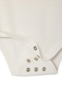 Nahaufnahme des Stoffs eines weißen Babybodys mit geöffneten metallenen Druckknöpfen im Schrittbereich, die Nähte zeigen.