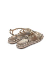 Sandali metallici dorati con decorazioni di perline, suola piatta e cinturino alla caviglia regolabile. Soletta testurizzata; design minimalista.